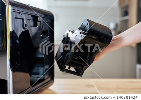 Hand removing brewing unit from automatic coffee machine Hand removing brewing unit from automatic coffee machine 140281424