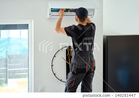 Man cleaning air conditioner filter at home 140281447