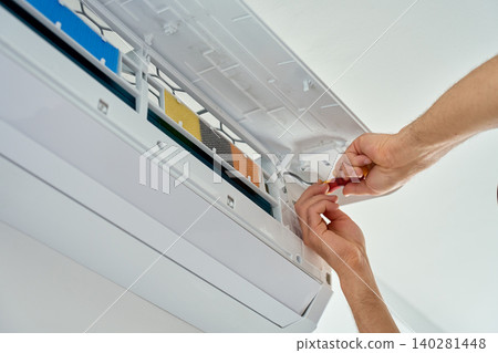 Hands repairing air conditioner with screwdriver Hands repairing air conditioner with screwdriver 140281448