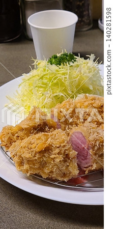 Crispy tonkatsu, a Japanese-style breaded and deep-fried pork cutlet, served with shredded cabbage and drizzled with savory sauce. A delightful balance of crunchy texture and juicy meat. Crispy tonkatsu, a Japanese-style breaded and deep-fried pork cutlet, served with shredded cabbage and drizzled with savory sauce. A delightful balance of crunchy texture and juicy meat. 140281598