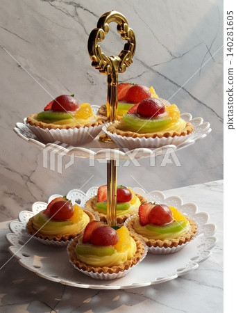 A delightful fruit tart with a buttery, flaky crust filled with creamy custard and topped with an array of fresh, vibrant fruits. Perfectly balanced between sweet and tangy, making it irresistible A delightful fruit tart with a buttery, flaky crust filled with creamy custard and topped with an array of fresh, vibrant fruits. Perfectly balanced between sweet and tangy, making it irresistible 140281605