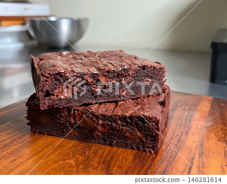 Rich, gooey fudge brownies with a dense, chocolatey center and a perfectly crisp top. Ideal for chocolate lovers craving a satisfying, indulgent treat. 140281614