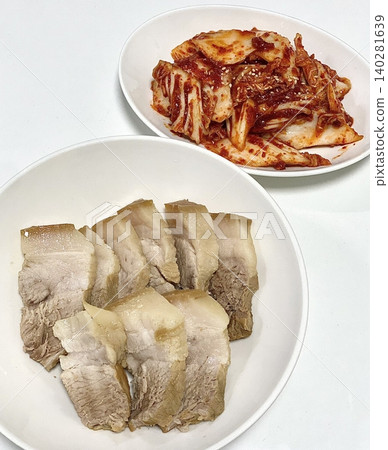 Tender slices of bossam, Korean boiled pork belly, served with fresh lettuce, garlic, and ssamjang. This flavorful and savory dish is perfect for wrapping and sharing in a traditional Korean meal. Tender slices of bossam, Korean boiled pork belly, served with fresh lettuce, garlic, and ssamjang. This flavorful and savory dish is perfect for wrapping and sharing in a traditional Korean meal. 140281639