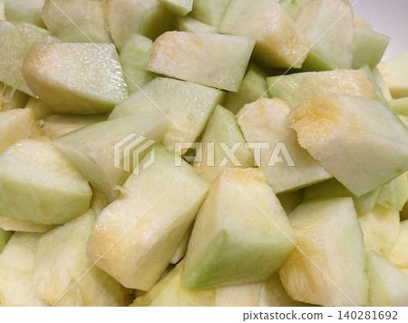 Fresh melon cubes neatly arranged in a bowl, showcasing their vibrant orange and green hues. A refreshing and visually appealing treat, perfect for any occasion. 140281692