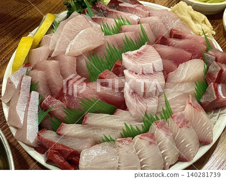 Fresh and delicate sashimi slices, beautifully presented with vibrant colors and perfect cuts. This traditional Japanese delicacy highlights the pure flavors of premium seafood. 140281739