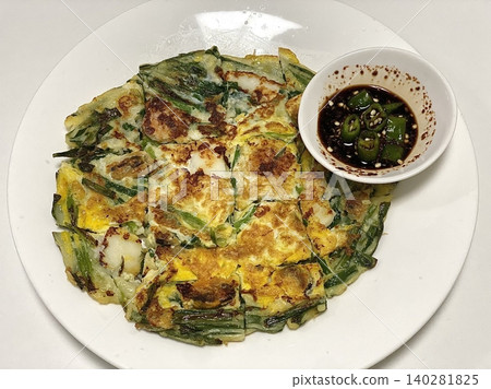 Pajeon is a savory Korean pancake made with green onions (pa) in a light batter, often mixed with seafood like squid or shrimp. Crispy on the outside and soft inside, it’s a flavorful side dish. 140281825