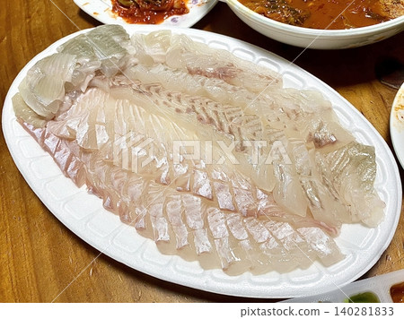 Fresh and delicate sashimi slices, beautifully presented with vibrant colors and perfect cuts. This traditional Japanese delicacy highlights the pure flavors of premium seafood. 140281833