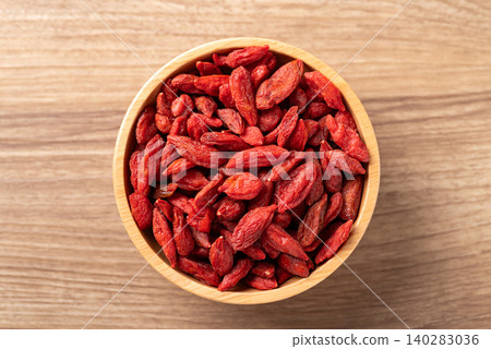 Organic dried goji berries in a bowl on wooden background. Healthy food. Table top view 140283036