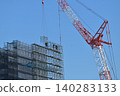 A construction worker assembling temporary scaffolding using a tower crane. 140283133