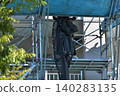 Scenes from the assembly of temporary scaffolding and installation of protective sheets during large-scale renovation of an apartment building. 140283135