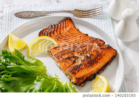 Grilled salmon steak on plate with fresh salad 140283193