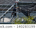 Scenes from the assembly of temporary scaffolding and installation of protective sheets during large-scale renovation of an apartment building. 140283199