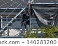 Scenes from the assembly of temporary scaffolding and installation of protective sheets during large-scale renovation of an apartment building. 140283200