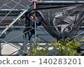 Scenes from the assembly of temporary scaffolding and installation of protective sheets during large-scale renovation of an apartment building. 140283201
