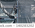 Scenes from the assembly of temporary scaffolding and installation of protective sheets during large-scale renovation of an apartment building. 140283202