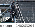 Scenes from the assembly of temporary scaffolding and installation of protective sheets during large-scale renovation of an apartment building. 140283204