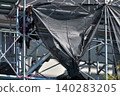 Scenes from the assembly of temporary scaffolding and installation of protective sheets during large-scale renovation of an apartment building. 140283205
