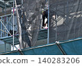 Scenes from the assembly of temporary scaffolding and installation of protective sheets during large-scale renovation of an apartment building. 140283206