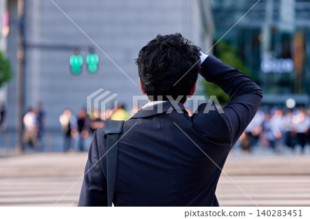 一位三十多歲的日本商人背對著鏡頭,站在辦公區,用手摀著額頭,看起來像是感冒了,身體不舒服。 一位三十多歲的日本商人背對著鏡頭,站在辦公區,用手摀著額頭,看起來像是感冒了,身體不舒服。 140283451