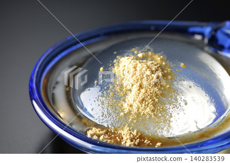 Mizuwara mochi served in a glass bowl, photographed against a black background. Mizuwara mochi served in a glass bowl, photographed against a black background. 140283539