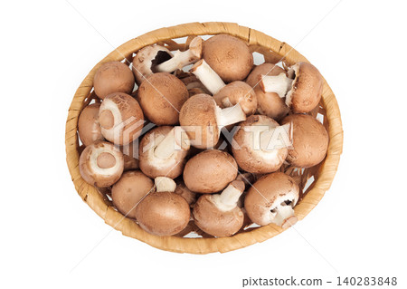 Brown champignon mushroom a wicker basket isolated on white background. Top view. Flat lay 140283848
