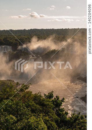 Majestic mist above powerful iguazu falls creates awe in lush green jungle 140284096