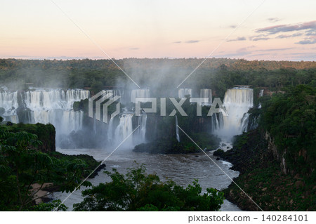 Majestic breathtaking iguazu falls nature landscape with mist over river at twilight 140284101