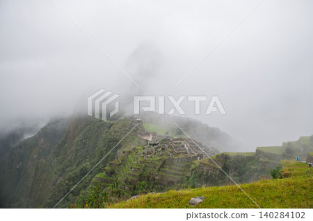 Mysterious machu picchu ancient stone ruin under heavy mountain fog Mysterious machu picchu ancient stone ruin under heavy mountain fog 140284102
