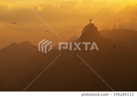 Serene sunset silhouette over mountain in Rio de Janeiro Brazil with famous statue and golden light Serene sunset silhouette over mountain in Rio de Janeiro Brazil with famous statue and golden light 140284113