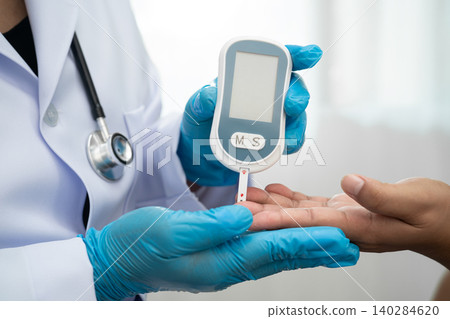Doctor check diabetes from finger blood sugar level with finger lancet. Doctor check diabetes from finger blood sugar level with finger lancet. 140284620