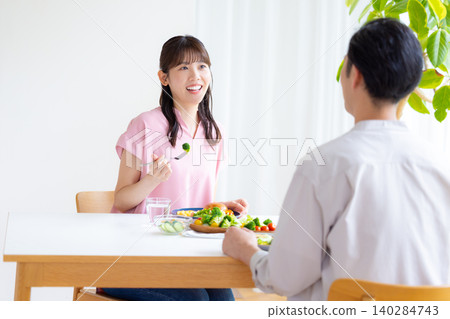 Family: Men and women eating a meal at home Family: Men and women eating a meal at home 140284743