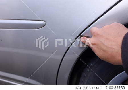 打磨汽車擋泥板上的刮痕的過程。 140285183