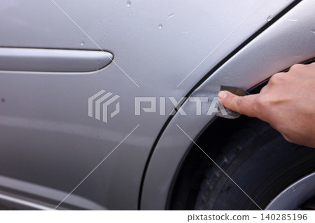 打磨汽車擋泥板上的刮痕的過程。 140285196