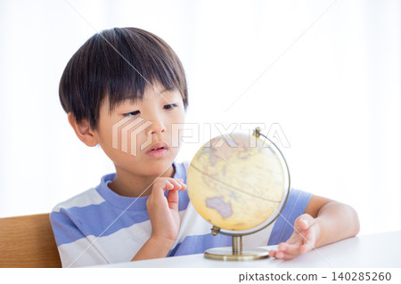 A boy looking at a globe A boy looking at a globe 140285260