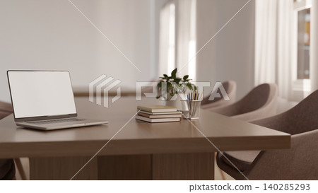 White screen laptop with books and pencils on wooden table with curved chairs in the cafe or library White screen laptop with books and pencils on wooden table with curved chairs in the cafe or library 140285293