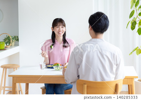 Family: Men and women eating a meal at home 140285333