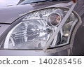 Removing masking tape after headlight cleaning. 140285456
