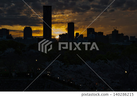 夕陽西下,櫻花盛開,城市天際線閃閃發光。 夕陽西下,櫻花盛開,城市天際線閃閃發光。 140286215