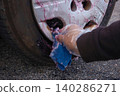 The process of cleaning iron filings attached to the wheels with an iron filing remover cleaner. 140286271