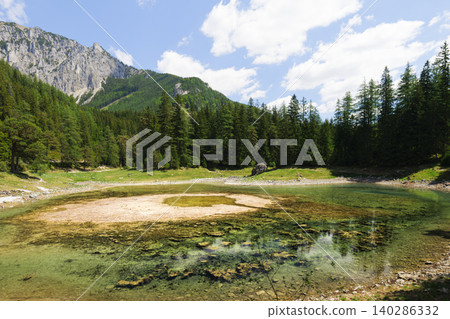 Crystal clear water of Gruner See with reflections in the Austrian Alps, capturing a pristine alpine lake landscape in spring Crystal clear water of Gruner See with reflections in the Austrian Alps, capturing a pristine alpine lake landscape in spring 140286332