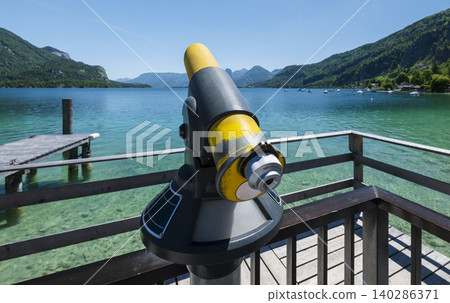 Coin operated telescope overlooking the scenic mountains and lake Wolfgangsee in the Austrian Alps, highlighting scenic viewpoint Coin operated telescope overlooking the scenic mountains and lake Wolfgangsee in the Austrian Alps, highlighting scenic viewpoint 140286371