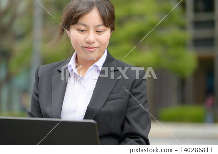 A recent Japanese businesswoman using a laptop computer. A recent Japanese businesswoman using a laptop computer. 140286811