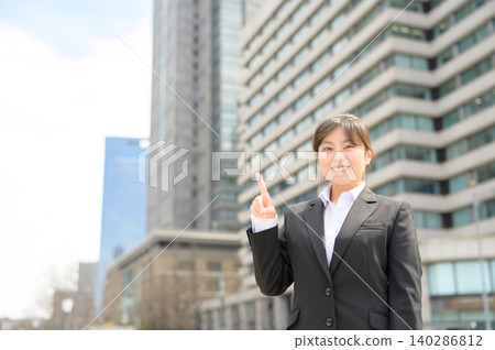 A Japanese woman in her 20s working in an office points her finger. 140286812