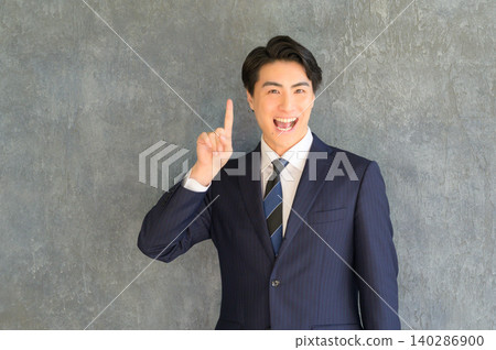A Japanese man with an idea against a gray background 140286900
