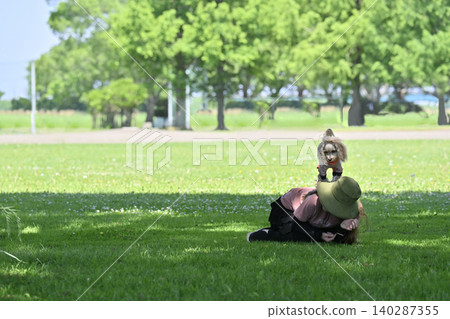 Dog dancing: Woman playing with her dog, a Maltipoo (Maltese x Toy Poodle). Dog dancing: Woman playing with her dog, a Maltipoo (Maltese x Toy Poodle). 140287355