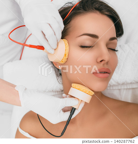Beautiful woman receiving body microcurrent procedure for facelift Beautiful woman receiving body microcurrent procedure for facelift 140287762