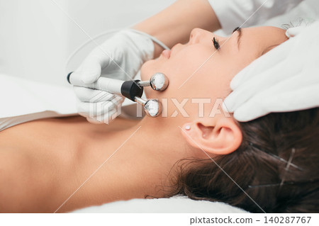 Beautiful woman receiving facial microcurrent procedure for rejuvenation skin. Beautiful woman receiving facial microcurrent procedure for rejuvenation skin. 140287767