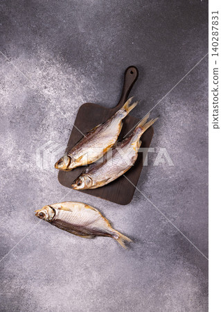 Dried salted fish on wooden board and gray background Dried salted fish on wooden board and gray background 140287831
