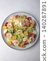 Caesar salad with tiger prawns, cherry tomatoes, croutons, parmesan cheese, quail eggs and romaine lettuce. Traditional American dish. Close-up, selective focus. 140287891