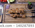 Traditional Russian shashlik on skewers with vegetables. Grilled pork meat (shish kebab). Close-up. 140287893